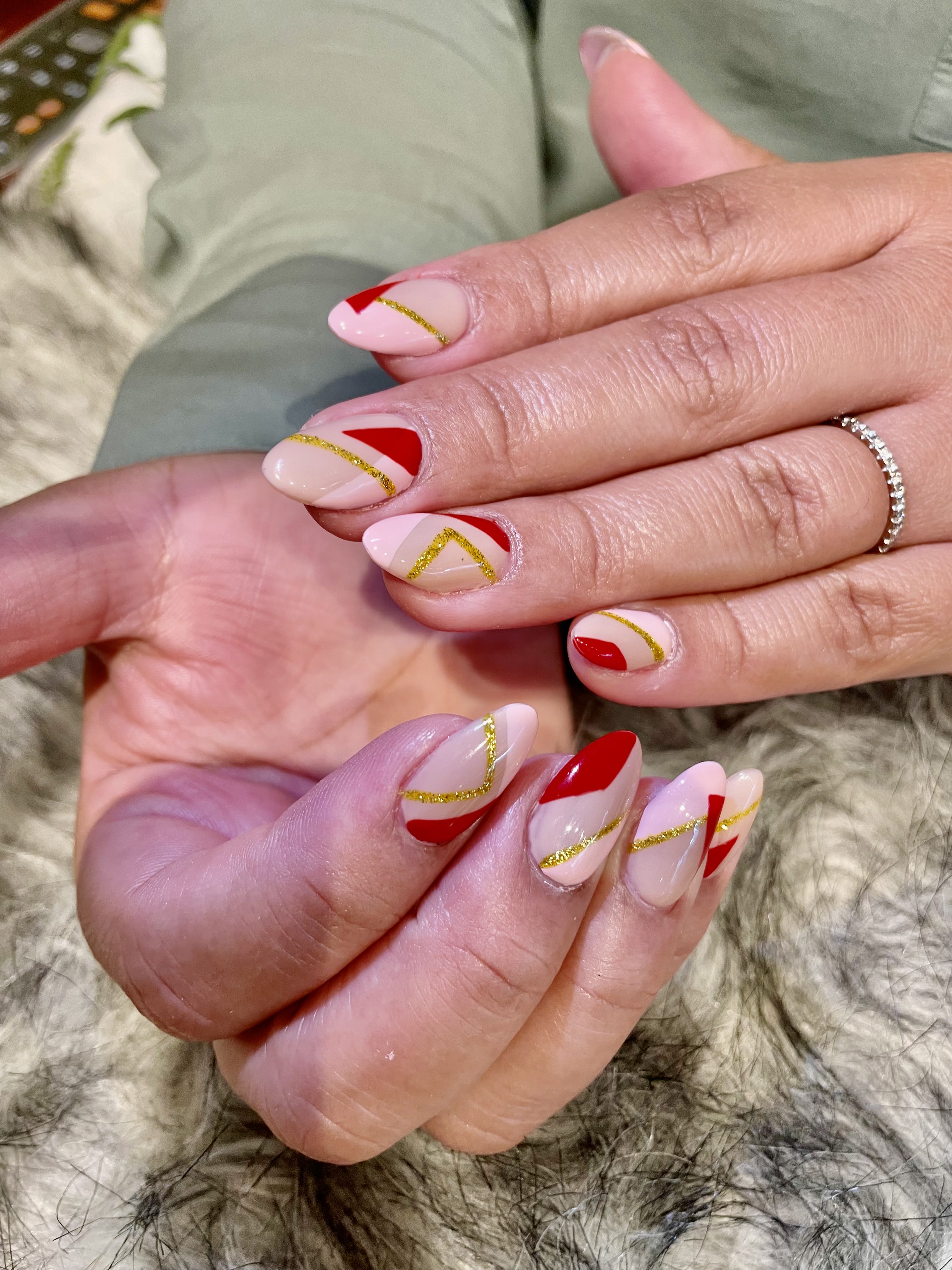 Nude almond nails with red and gold geometric art