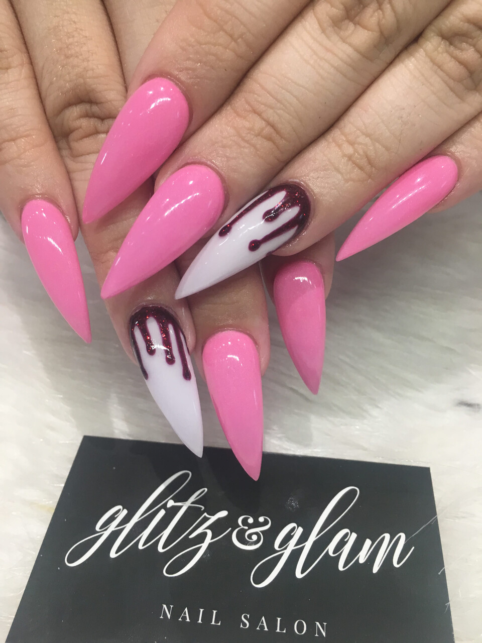 Pink stiletto nails with drip art — Glitz & Glam logo card